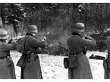 Two men in uniforms are shooting a gun.