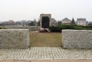 A stone wall with two large stones in front of it.