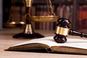 A judge 's gavel sitting on top of an open book.