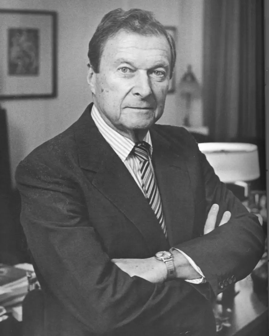 A man in suit and tie with his arms crossed.