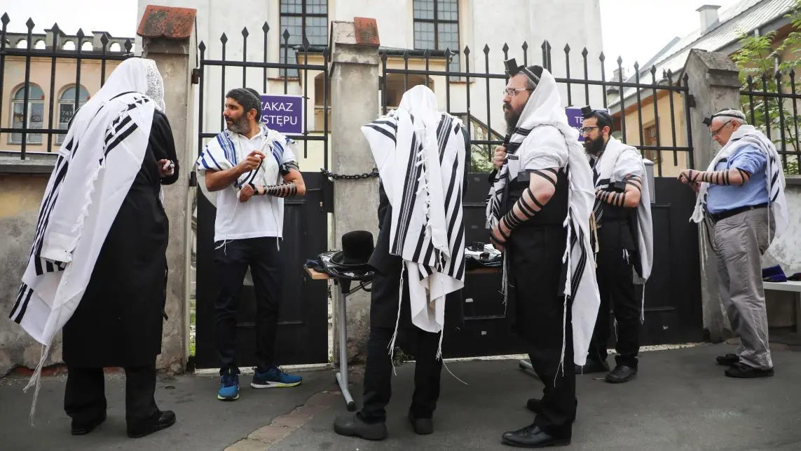 A group of men standing around in front of a building.