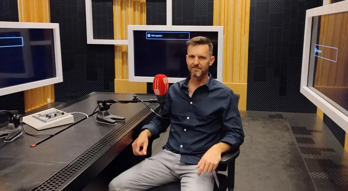 Man in a radio studio with a microphone.